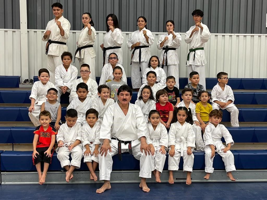 group of children and adults all wearing white karate uniforms